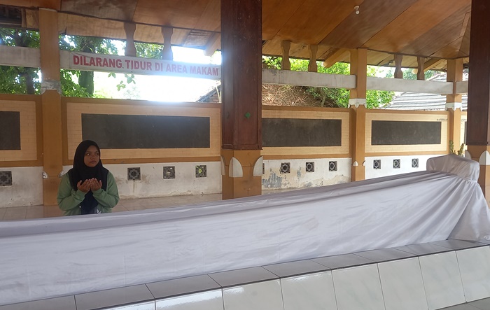 SAKRAL: Peziarah berdoa di Makam Sunan Ngundung di kompleks Makam Troloyo, Dusun Sidodadi, Desa Sentonorejo, Kecamatan Trowulan, Kabupaten Mojokerto. (foto: Laila Ramadani for Radar Majapahit)