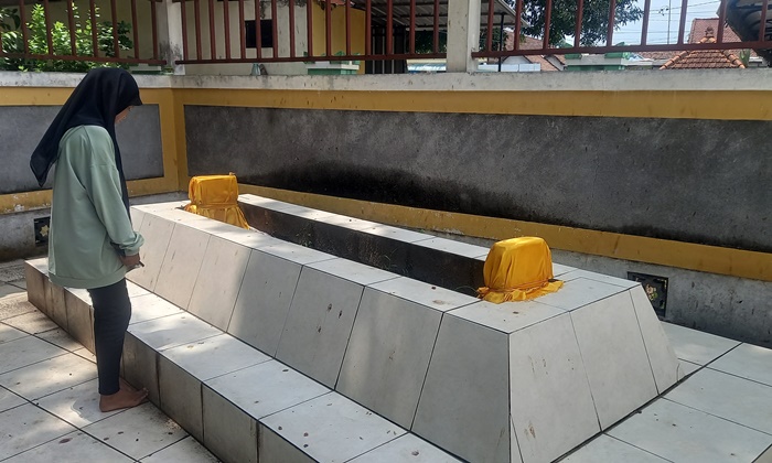 SAKRAL: Pengunjung memerhatikan Makam Raden Chusen, santri Temenggung Satim Singomoyo, di kompleks Makam Troloyo, Desa Sentonorejo, Kecamatan Trowulan. (foto: Annisa Fadilah for Radar Majapahit)