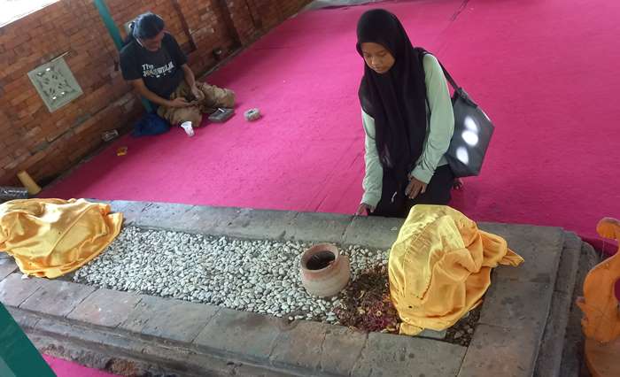 TERJAGA: Pengunjung melihat makam yang terawat di Makam Emban Kinasih di Dusun Sidodadi, Desa Sentonorejo, Kecamatan Trowulan, Kabupaten Mojokerto. (foto: Annisa Fadilah for Radar Majapahit)