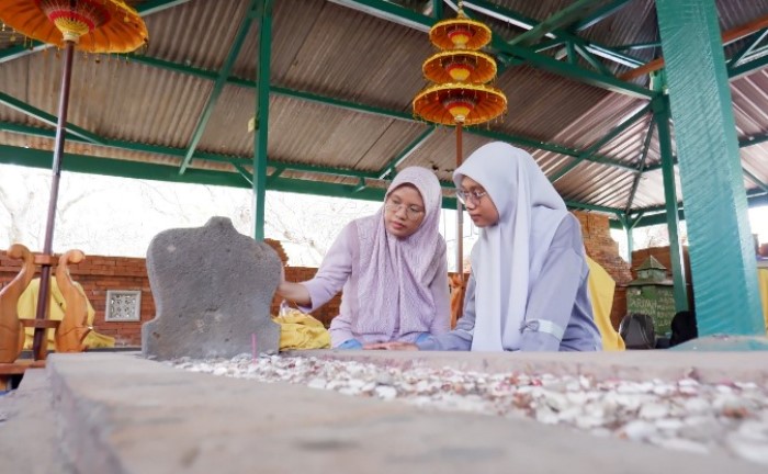 MENGENANG JASA: Pengunjung mengamati makam Tujuh Troloyo, di Dusun Sidodadi, Desa Sentonorejo, Kecamatan Trowulan, Kabupaten Mojokerto. (foto: Misbakhul Ulum for Radar Majapahit)