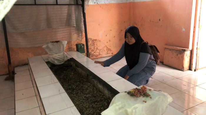 MENGAMATI: Peziarah sedang membersihkan area makam Makam Mbah Buyut Binorong. (Foto: Bryan Noer for Radar Majapahit)