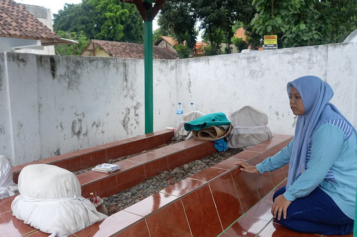 KERAMAT: Pengunjung mengamati makam Ki Ageng Surgi di Dusun Sidodadi, Desa Sentonorejo, Kecamatan Trowulan, Kabupaten Mojokerto. (foto: Laila Ramadani for Radar Majapahit)
