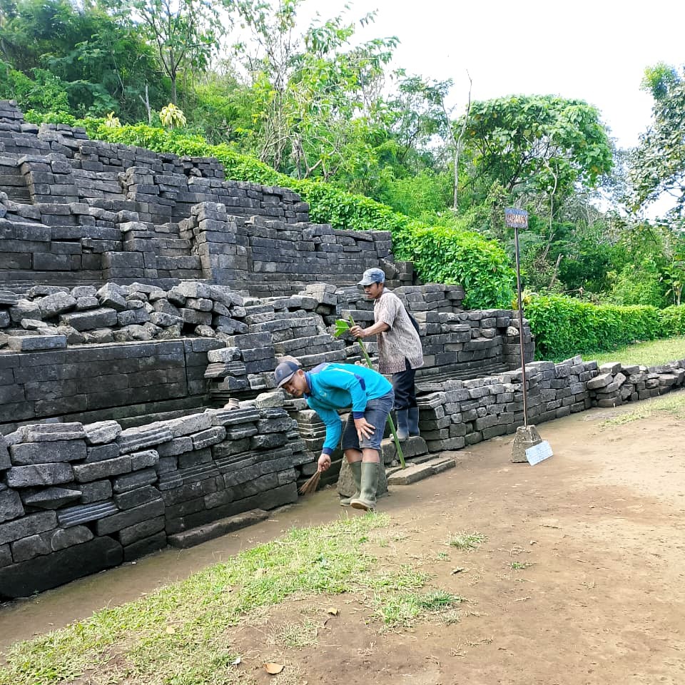 PEMELIHARAAN: Petugas membersihkan struktur Candi Carik yang ada di kawasan cagar budaya Gunung Penanggungan.