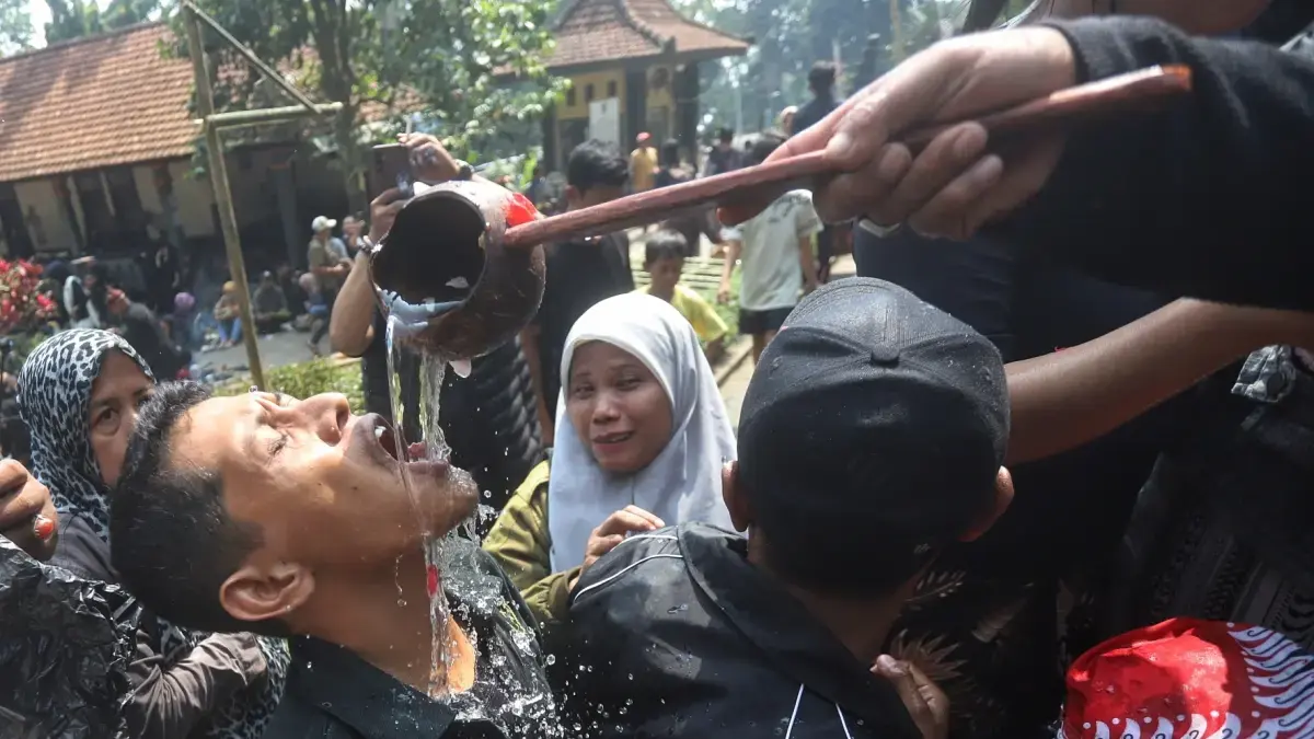 TRADISI: Warga meminum air dari sumber Petirtaan Jolotundo pada prosesi Ruwat Agung dalam rangka menyambut Bulan Suro atau Tahun Baru 1448 Hijriyah, Kamis (18/6). 