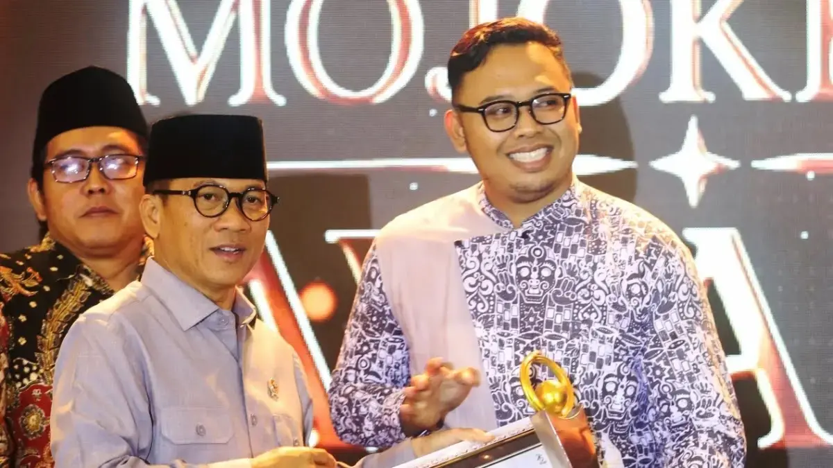 BUAH KOMITMEN: Kepala Desa Bejijong Pradana Tera Mardiatna menerima penghargaan kategori Katalisator Wisata Sejarah dan Edukasi Nusantara Jawa Pos Radar Mojokerto Award 2026, di Ballroom Sunrise Hotel Mojokerto, Selasa (7/7). Penghargaan diberikan oleh Menteri Desa dan PDT Yandri Susanto. (Sofan JPRM)