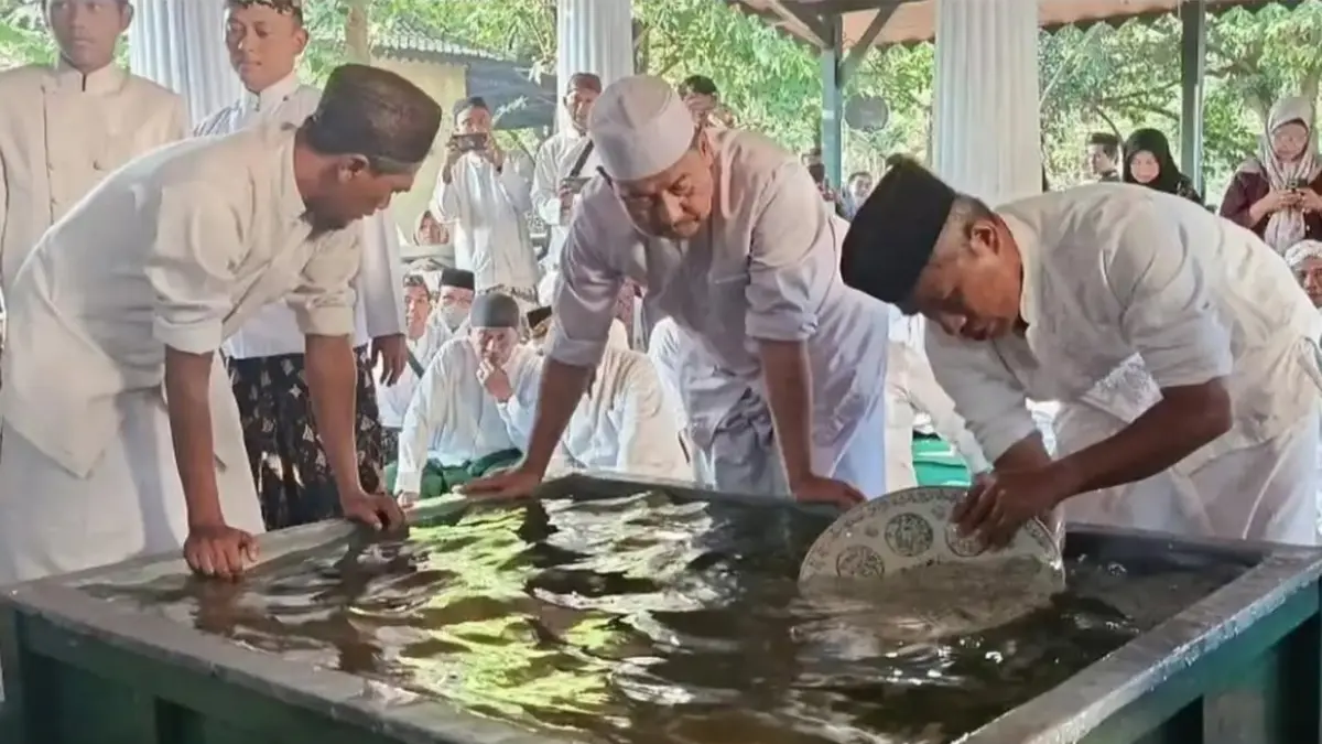 TRADISI: Para abdi dalem Keraton Kasepuhan Cirebon dengan pakaian serba putih secara khusyuk menyiram dan mengelap pusaka-pusaka peninggalan leluhur di dalam bak besar berisi air. (Foto: Balai Budaya Kemenbud RI)
