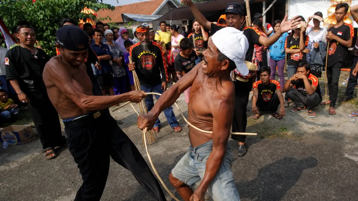 CAMBUK: Pertunjukan Ojung di Desa Ngembeh, Kecamatan Dlanggu, Kabupaten Mojokerto, beberapa waktu lalu. (Foto: Sofan Kurniawan/Jawa Pos Radar Mojokerto).