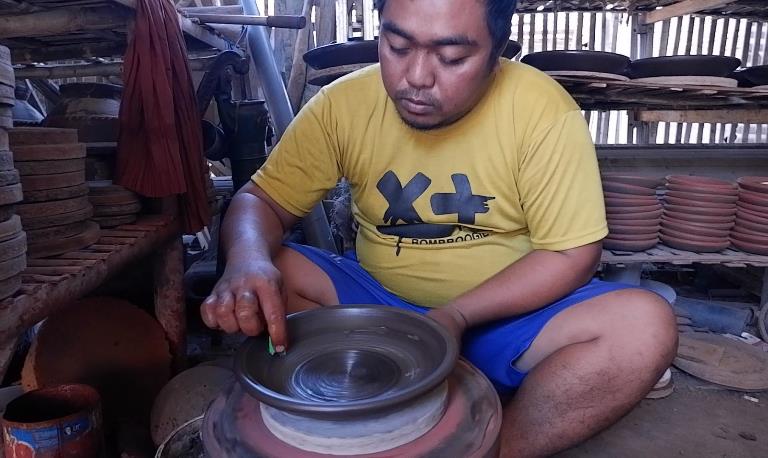 TERAMPIL: Ahmad Sodikin, perajin melakukan pewarnaan cobek sebelum melalui proses pembakaran, di rumahnya, Dusun Bedog, Desa Mlaten, Kecamatan Puri, Senin (11/9).