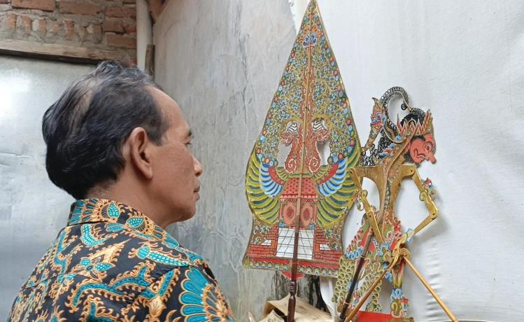 PIAWAI: Ki Dalang Suwoto menunjukkan kemampuannya dalam mendalang di rumahnya Dusun Sasap, Desa Modongan, Kecamatan Sooko, Kabupaten Mojokerto. (foto: rizki firmansyah)