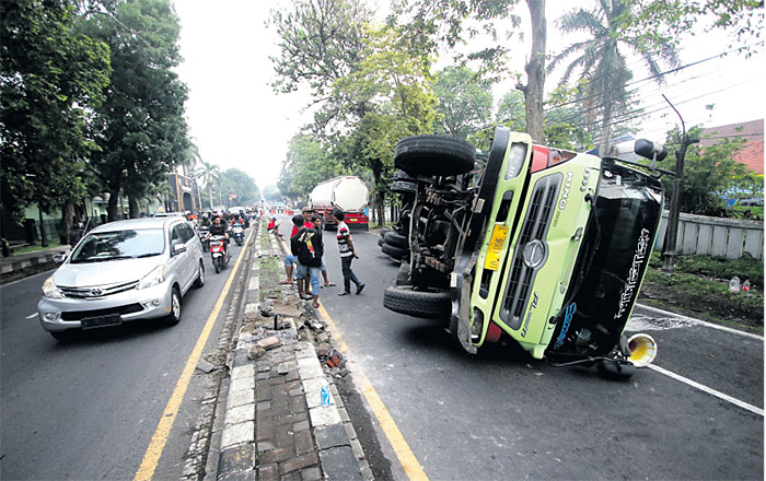 CELAKA: Kondisi truk tronton tangki yang terguling di Jalan Raya Singosari sebelum dievakuasi dengan menggunakan crane kemarin.