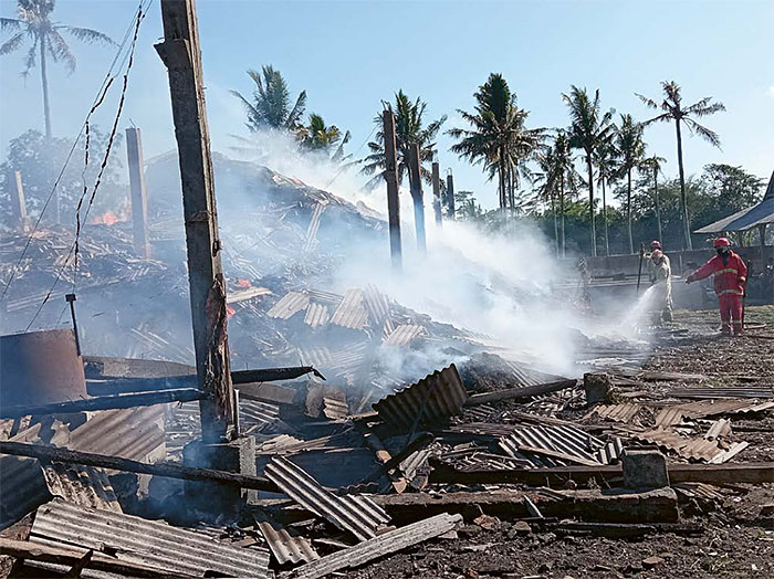 SULIT PADAM: Petugas Damkar Kabupaten Malang berusaha memadamkan api di gudang penyimpanan ampas tebu di Jalan Panglima Sudirman, Dusun Wates, Desa Gondanglegi Wetan, Kecamatan Gondanglegi kemarin.