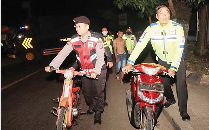 DITUNTUN: Petugas kepolisian mengamankan sepeda motor yang menjadi barang bukti balapan liar di kawasan Kepanjen. Pemilik kendaraan tersebut dikenakan tilang.