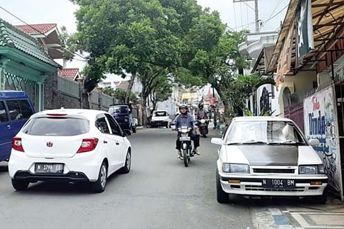 GANGGU WARGA:  Mobil yang parkir  di tepi Jalan Diran  Kelurahan Sisir  dikeluhkan oleh  masyarakat dan  pengguna jalan.