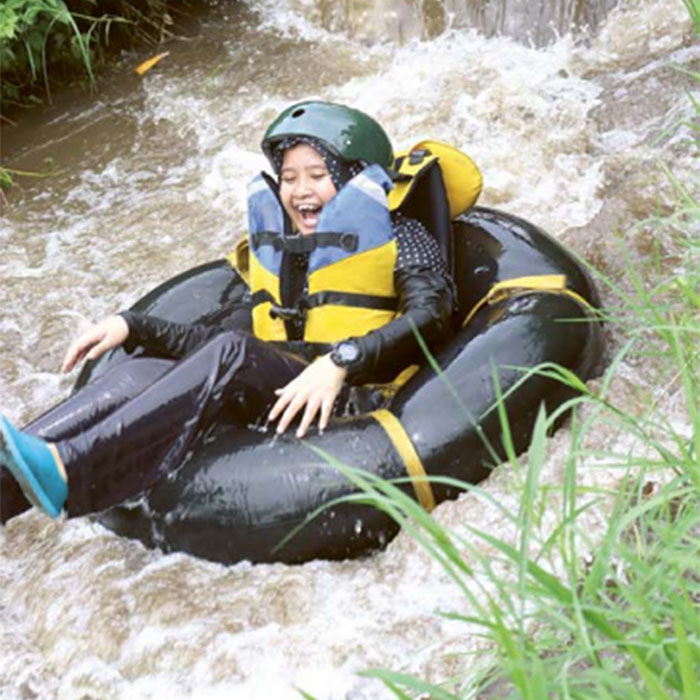 SERU: Salah seorang wisatawan menikmati wisata tubing di sungai yang ada di Kelurahan Temas.