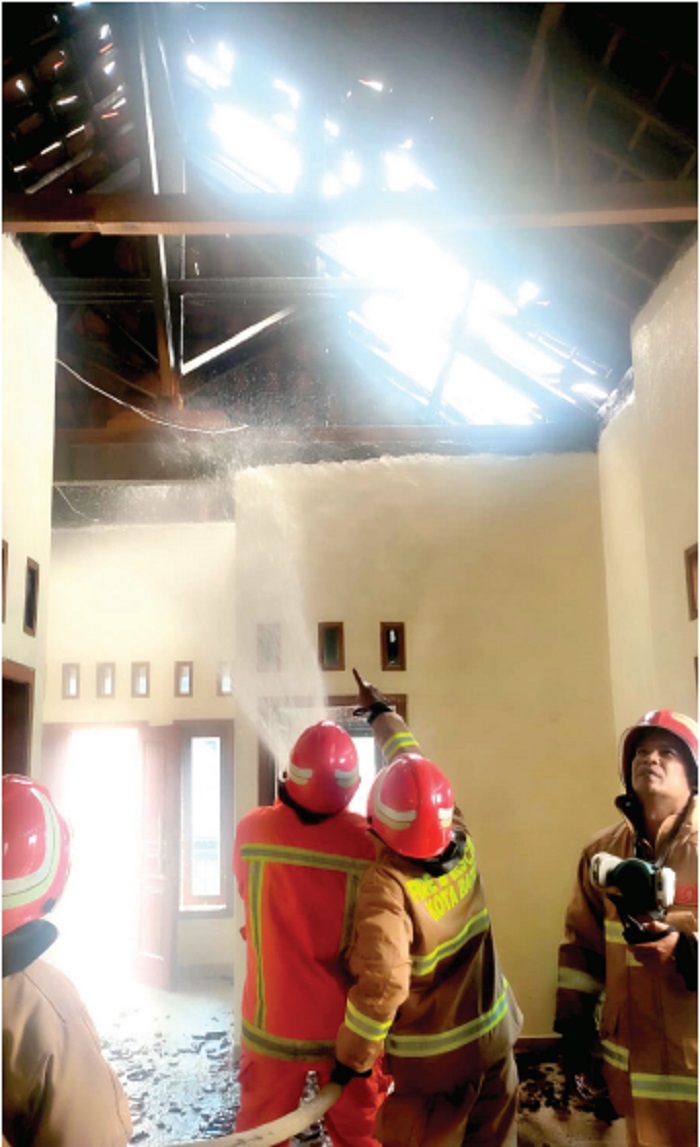 Petugas Damkar Kabupaten Malang berjibaku memadamkan kobaran api di rumah warga Pujon (23/1).