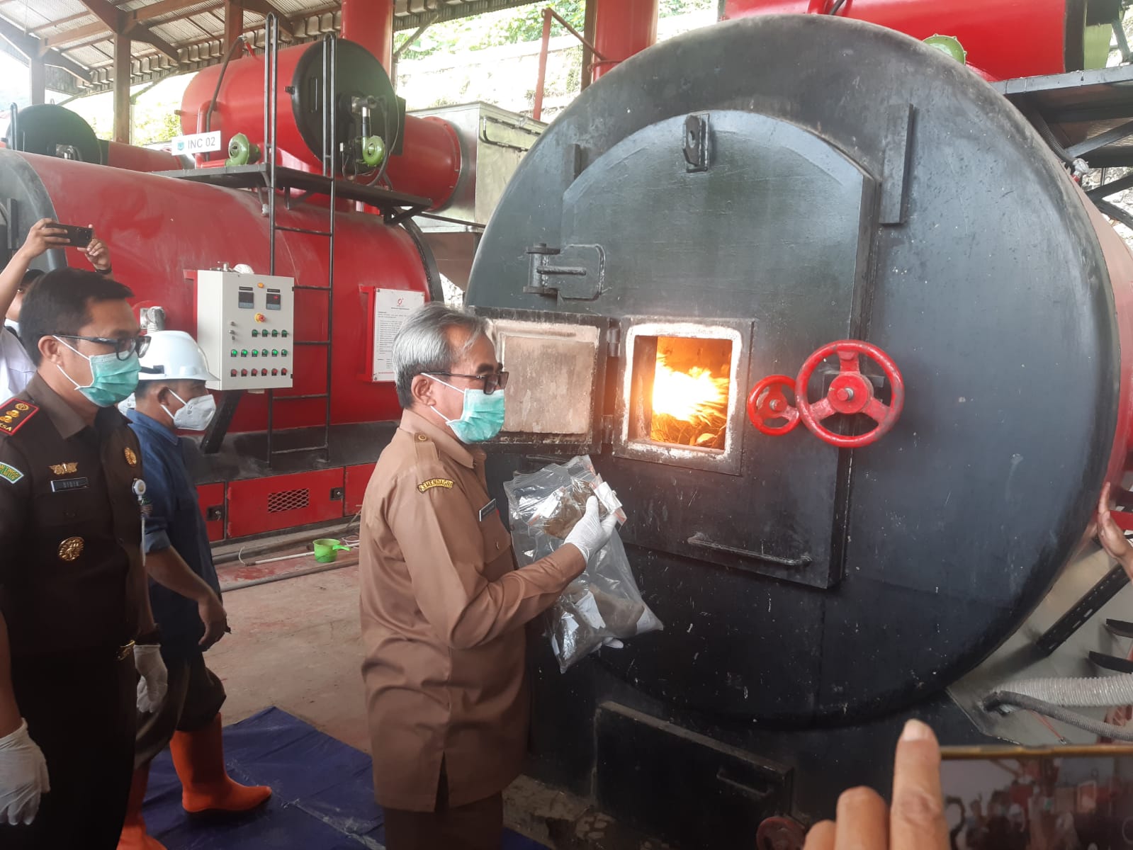 DIMUSNAHKAN: Kajari Kota Batu memasukkan barang bukti ke tempat pembakaran di TPA Tlekung, kemarin (6/2).