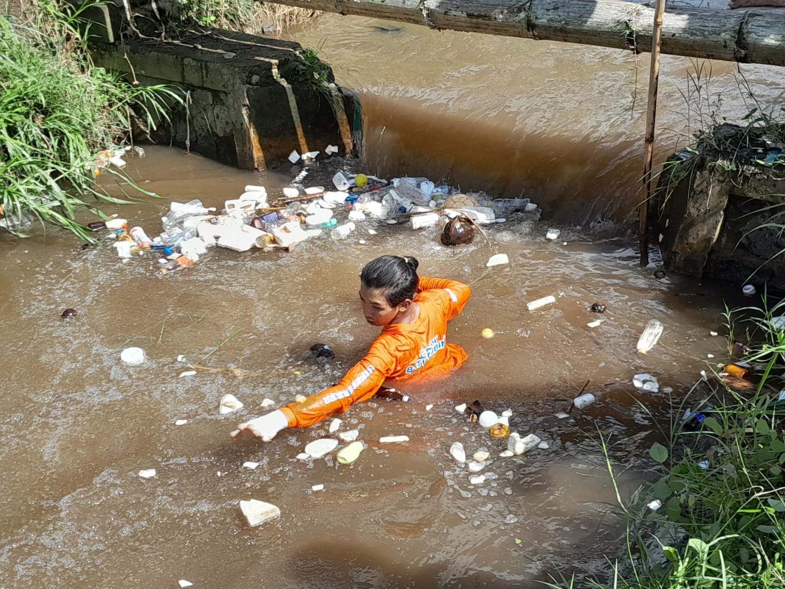 PEDULI: Anggota tim Sabers Pungli Kota Batu membersihkan sampah di sungai.