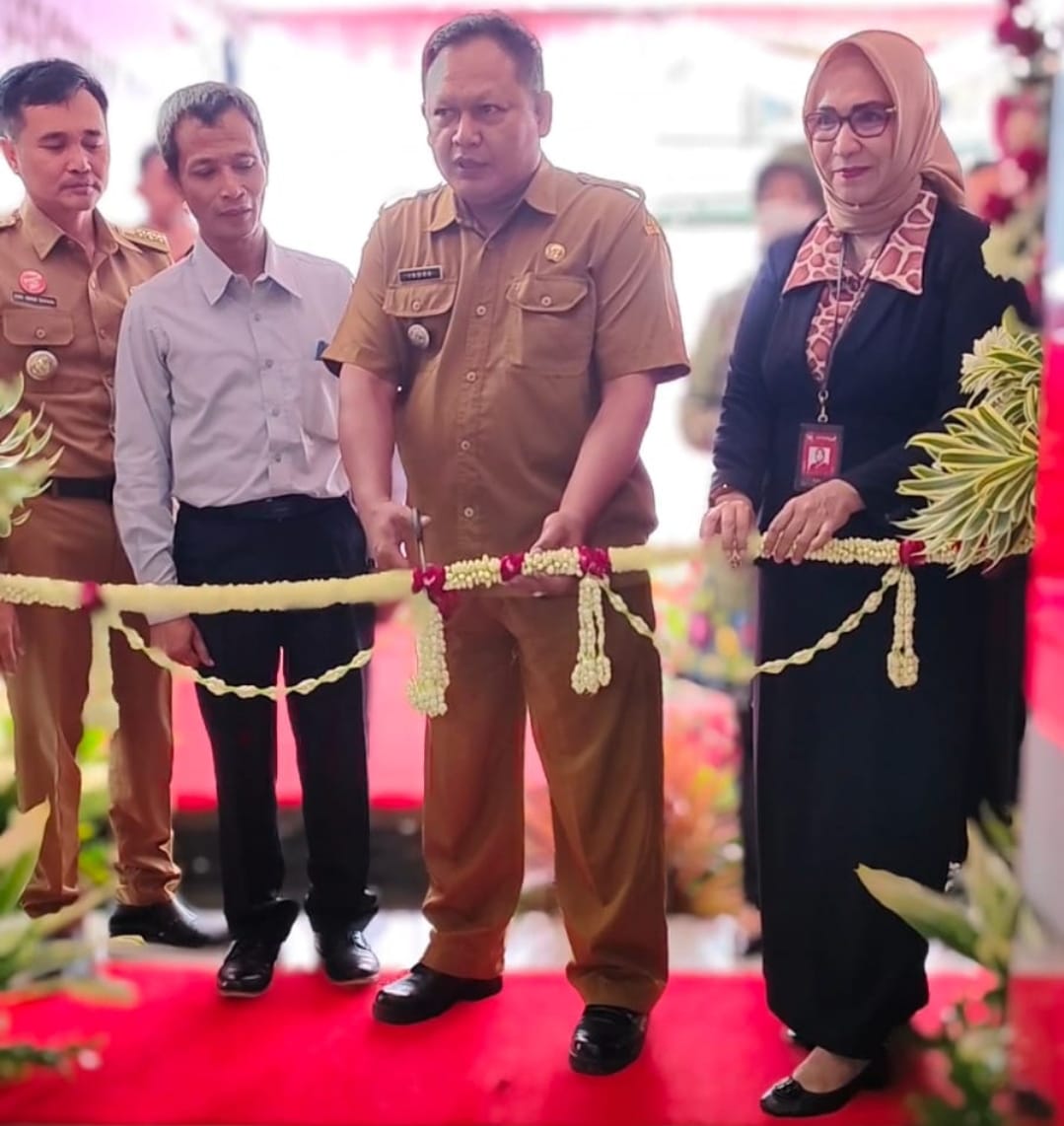 RESMI DIBUKA: Camat Pujon Indra Gunawan didampingi Pimpinan Pusat Bank Jatim Kota Batu Ibu Sugi Astuti memotong pita sebagai tanda peresmian Bank Jatim KCP Pujon.