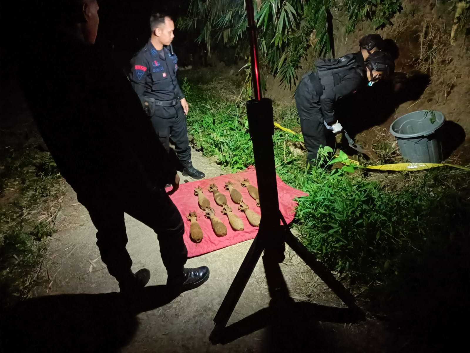 EVAKUASI: Tim   dari Unit Penjinak Bom Detasemen Gegana Satbrimob Polda Jawa Timur mengevakuasi mortir yang terpendam, Senin malam (6/5).