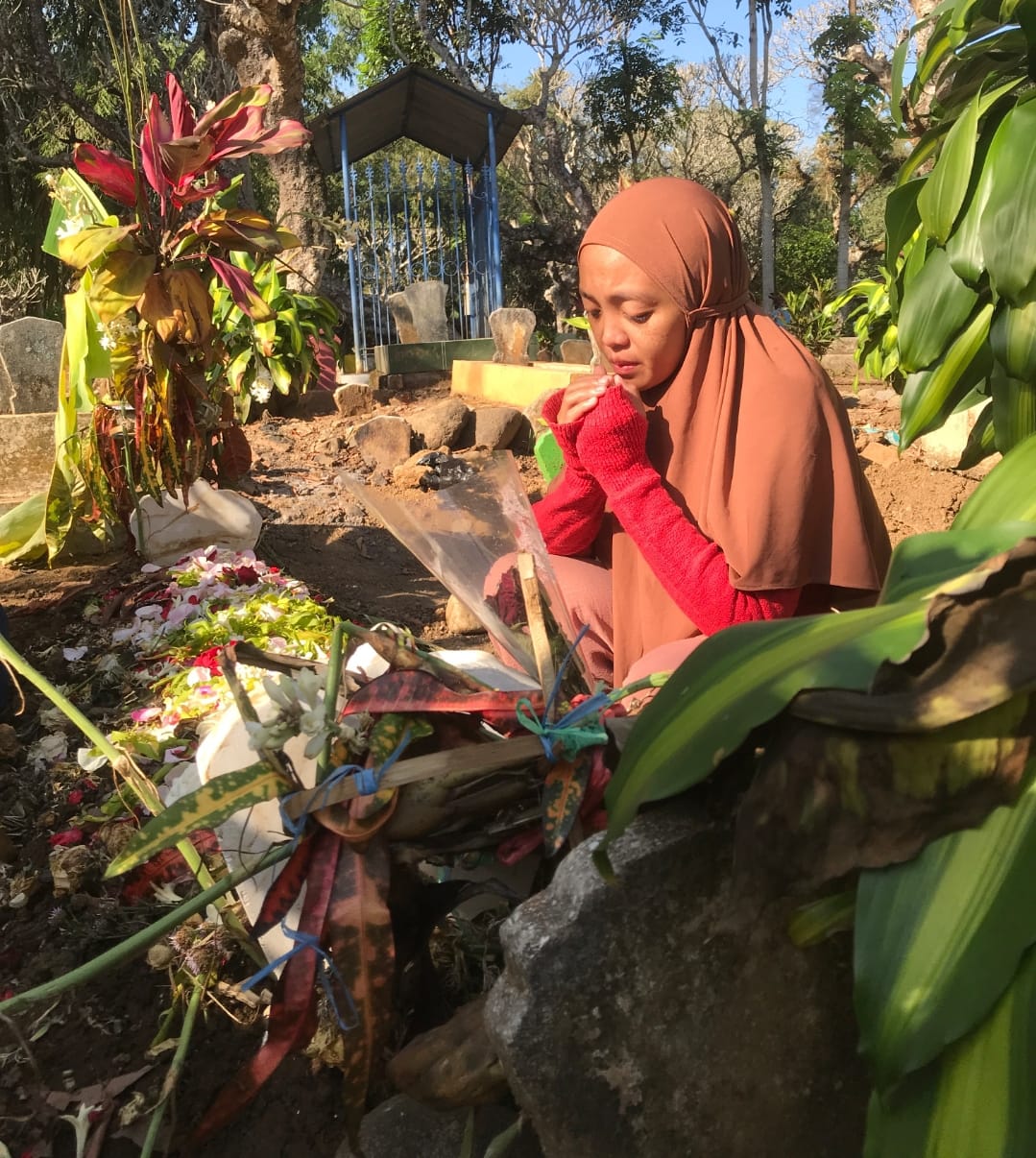 SEDIH MENDALAM: Nurul menangis di makam putranya NWK yang meninggal karena dianiaya temannya (6/6).