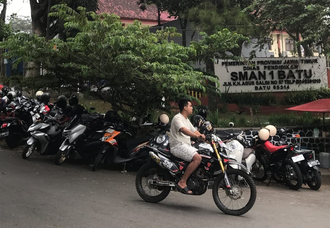 BALIK LAGI: Para pelajar SMAN 1 Kota Batu kembali memarkir sepeda motornya di tepi Jalan Agus Salim yang bukan menjadi tempat parkir, Jumat (14/6).