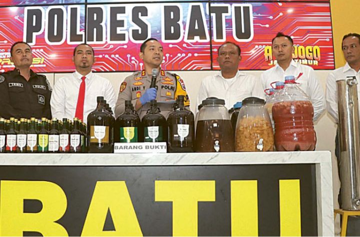 BARANG BUKTI: Polres Batu menunjukkan barang bukti dari hasil penggerebekan home industry minuman keras yang berada di Desa Junrejo, Selasa (20/8)