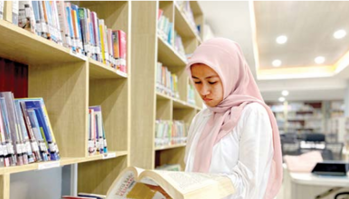 FOKUS: Salah seorang pemustaka membaca salah satu koleksi buku di  Perpustakaan Umum Daerah Kota Batu Selasa lalu (1/10).