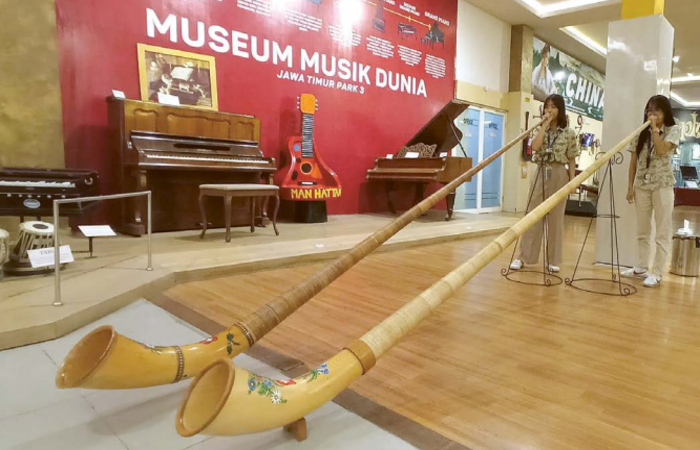 UNIK: Beberapa pengunjung memainkan alat musik alphorn yang disimpan di Museum Musik Dunia Jatim Park 3 beberapa waktu lalu.