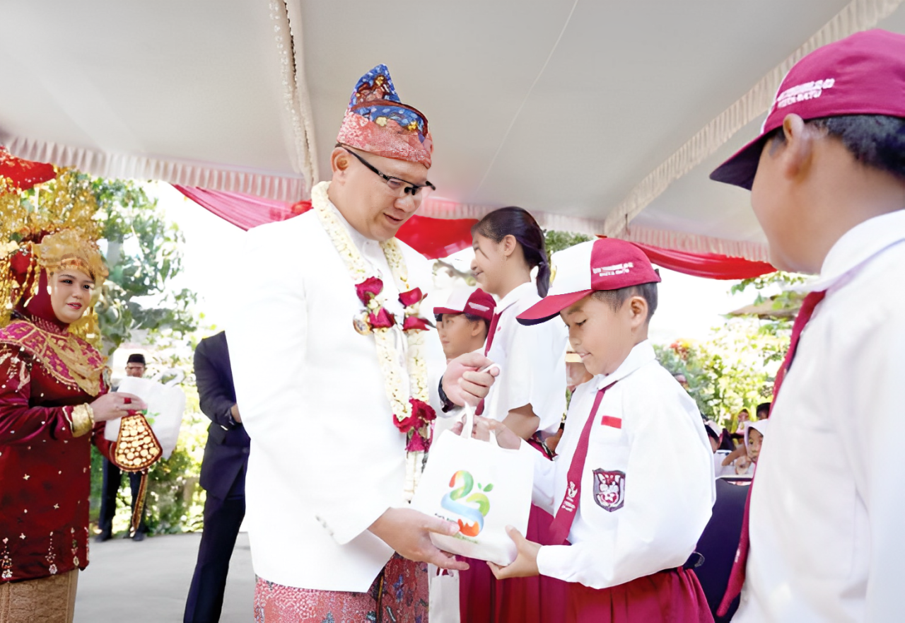 BAHAGIA: Pj Wali Kota Batu Aries Agung Paewai memberikan paket makanan bergizi kepada pelajar di Kecamatan Junrejo kemarin (28/10).