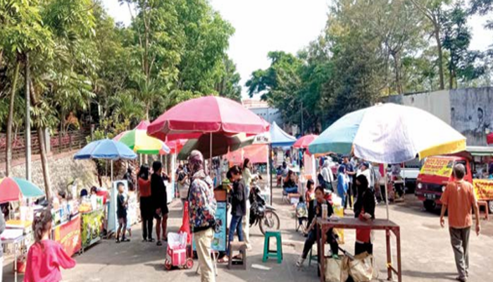 TIDAK SERAGAM: Payungan yang digunakan PKL di CFD Among Healthy kemarin (10/11) masih beragam. Kedepan Pemkot Batu akan menyamakan booth PKL di sana.