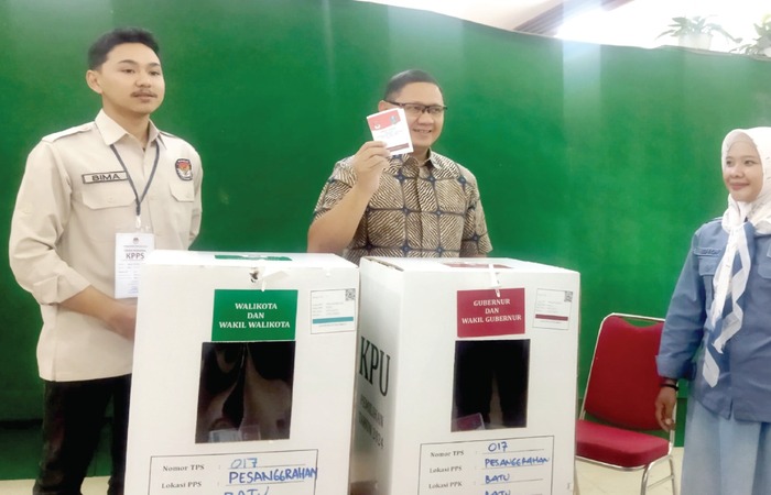 Pj Wali Kota Batu Aries Agung Paewai menunjukkan surat suara yang sudah dia coblos kepada awak media di Tempat Pemungutan Suara (TPS) 17 di UPT Laboratorium Herbal Materia Medica di Jalan Lahor.