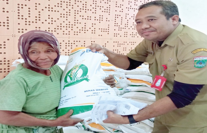 TERSALURKAN: Salah seorang warga Desa Giripurno, Kecamatan Bumiaji menerima bantuan beras dari pemerintah kemarin (10/12).