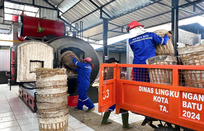 SIAP DIGUNAKAN: Beberapa petugas memasukkan sejumlah sampah ke insinerator di Kelurahan Dadaprejo kemarin (23/12). Itu sekaligus uji coba perdana pengoperasian mesin pembakaran tersebut.