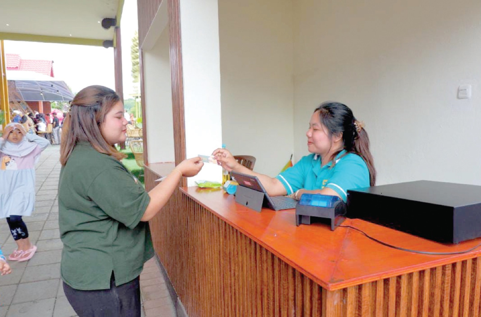 TRANSAKSI: Salah seorang petugas loket masuk Dufan memberikan  voucher senilai Rp 5 ribu kepada pengunjung beberapa waktu lalu.