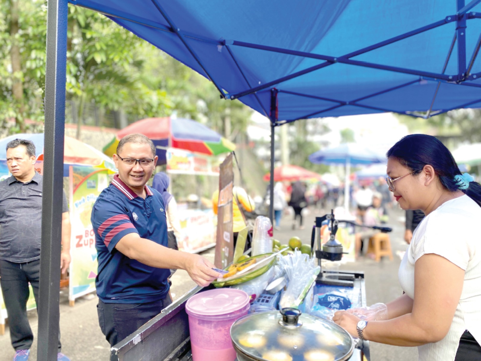 BERI APRESIASI: Pj Wali Kota Batu Aries Agung Paewai membeli makanan di salah satu lapak PKL CFD Among Healthy kemarin (5/12). RORI DINANDA BESTARI/RADAR BATU