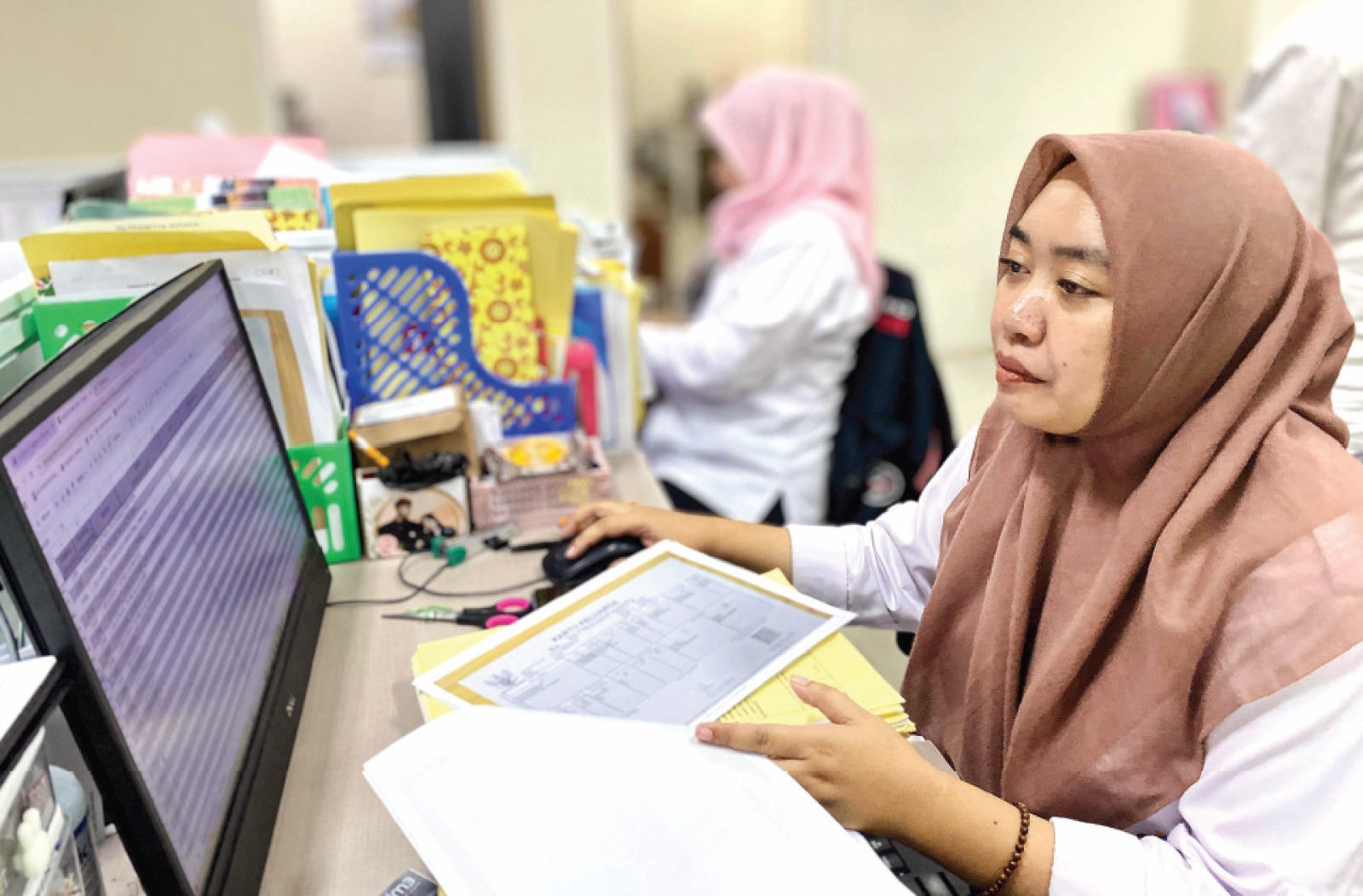 FOKUS: Petugas adminduk sedang memasukkan data pengajuan permohonan kartu keluarga di Kantor Dispendukcapil Kota Batu beberapa waktu lalu. (RORI DINANDA BESTARI/RADAR BATU)