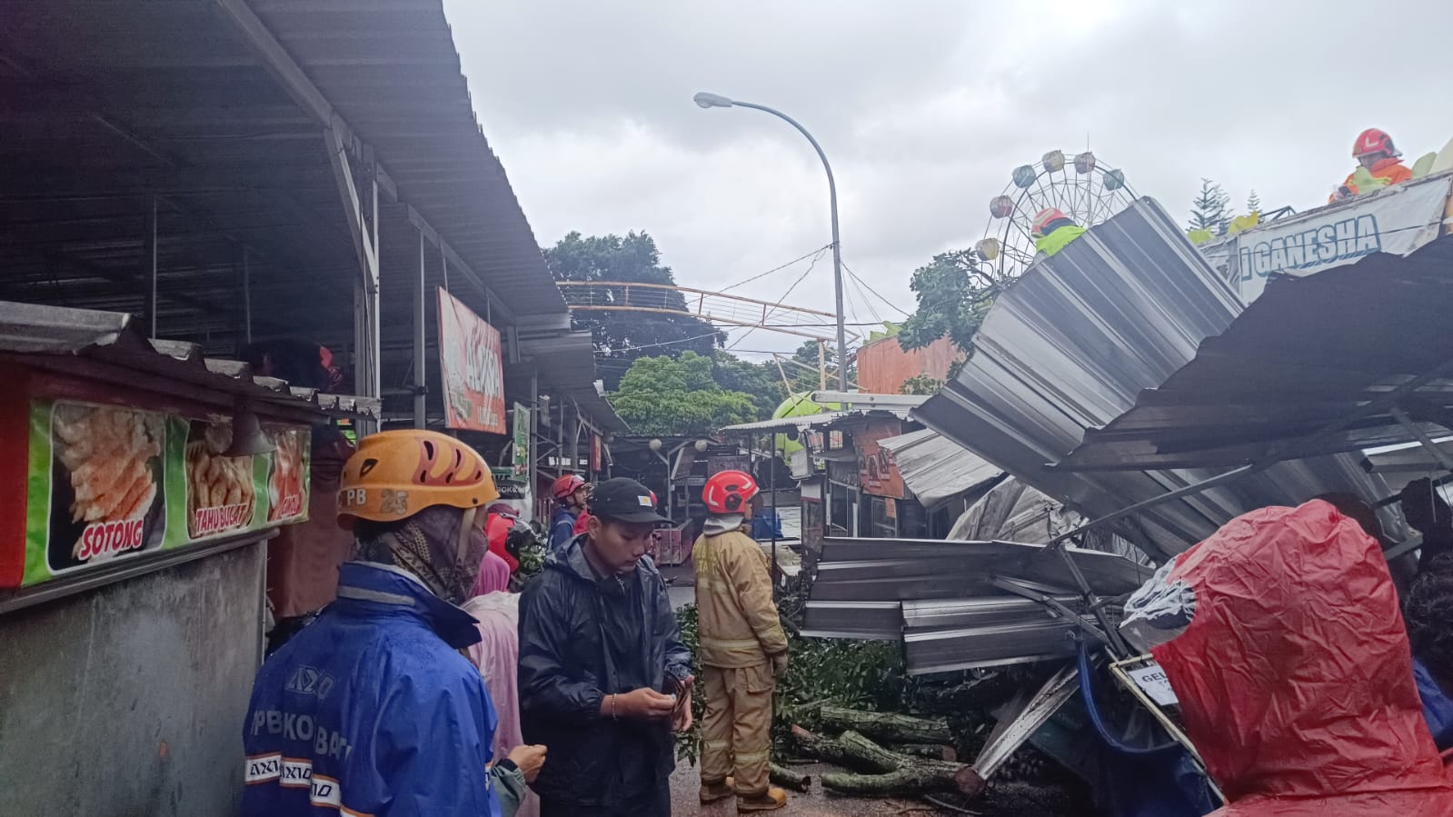 RUSAK: Pohon Mahoni di Jalan Kartini, Kelurahan Ngaglik, tumbang dan menimpa 5 lapak PKL Alun-Alun Kota Wisata Batu kemarin (30/1). (BPBD KOTA BATU FOR RADAR BATU)