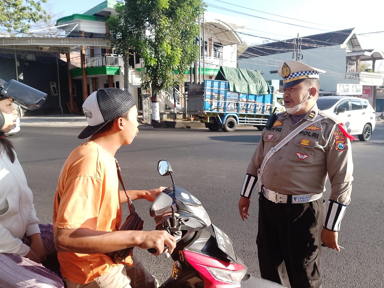 MELANGGAR: Salah seorang personel Polres Batu menghentikan warga yang kedapatan tak mengenakan helm saat berkendara di simpang tiga Desa Pendem, Kecamatan Junrejo beberapa waktu lalu.