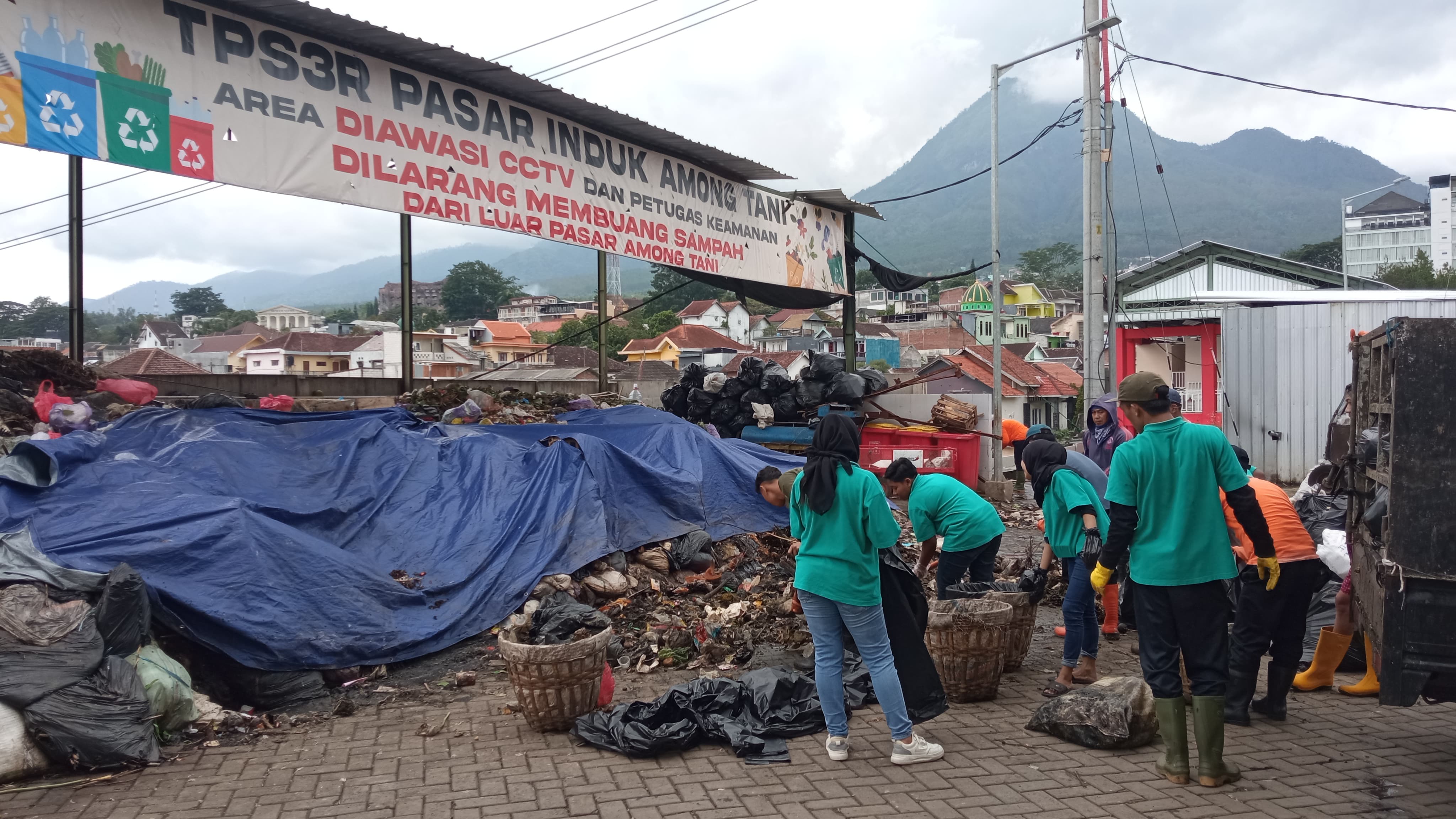PENGANGKUTAN: Sejumlah petugas kebersihan pasar induk dan petugas DLH sedang memilah sampah dan kemudian mengangkutnya menuju TPA Tlekung beberapa waktu lalu. (MOH RIZAL/RADAR BATU)