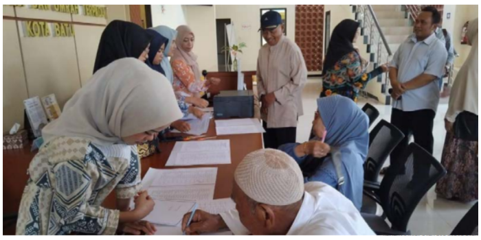 Petugas Kemenag Kota Batu menjelaskan proses pelunasan bipih kepada calon jemaah haji. (KEMENAG KOTA BATU FOR RADAR BATU)