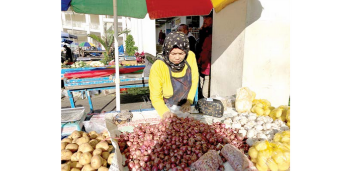 PRODUK UNGGULAN: Salah seorang pedagang pasar pagi menjajakan bawang merah dari Desa Torongrejo, Kecamatan Junrejo di Pasar Induk Among Tani Batu beberapa waktu lalu. (RORI DINANDA BESTARI/RADAR BATU)