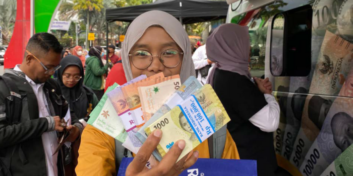 BERHASIL TUKAR: Salah seorang warga menunjukkan uang baru yang ditukar melalui Mobil Kas Keliling Bank Indonesia (BI) Malang di Alun-Alun Kota Wisata Batu kemarin (12/3).