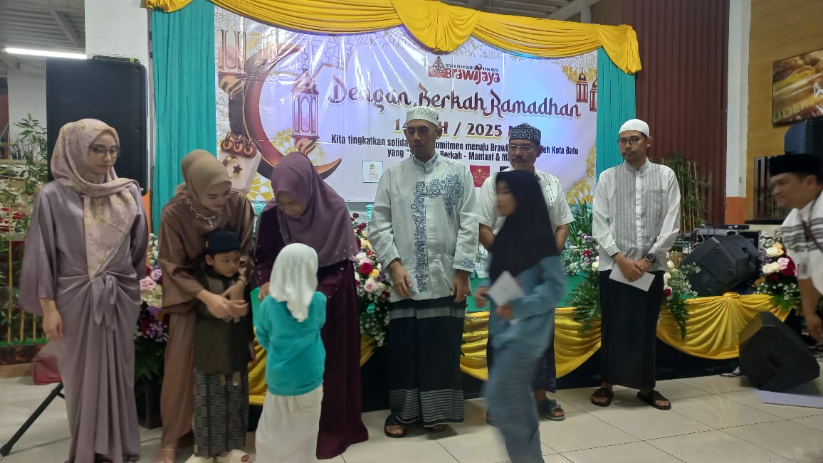 BERBAGI: Keluarga owner Oleh-Oleh Brawijaya Kota Batu membagikan uang saku kepada anak-anak yatim, Minggu (16/3/25)