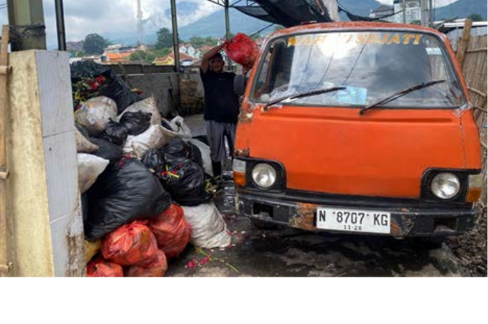 RUTIN DIANGKUT: Petugas sampah dari DLH Kota Batu mengangkut tumpukan sampah di TPS 3R Pasar Induk Among Tani Batu kemarin (17/3). (RORI DINANDA BESTARI/RADAR BATU)