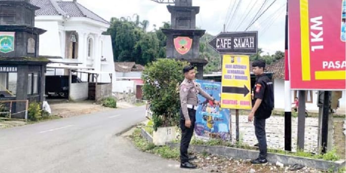 PEMASANGAN RAMBURAMBU: Personel Satlantas Polres Batu sedang memasang petunjuk arah rekayasa lalu lintas di Kecamatan Pujon.