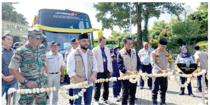 PEMBERANGKATAN: Wali Kota Batu Nurochman dan Wakil Wali Kota Batu Heli Suyanto menggunting pita sebagai tanda pemberangkatan peserta mudik gratis secara resmi (28/3).(RORI DINANDA BESTARI/RADAR BATU)