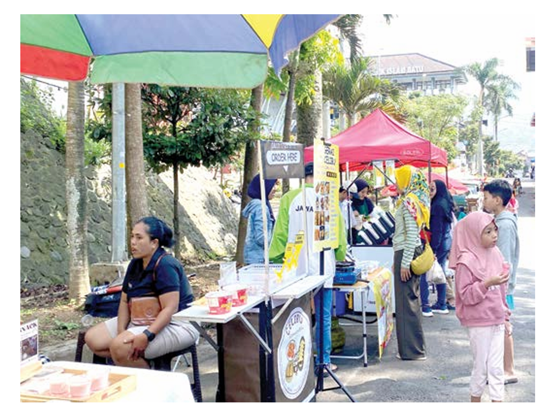 RAMAI PENGUNJUNG: Beberapa wisatawan membeli makanan di lapak para PKL CFD Among Healthy kemarin pagi (6/4). (RORI DINANDA BESTARI/RADAR BATU)