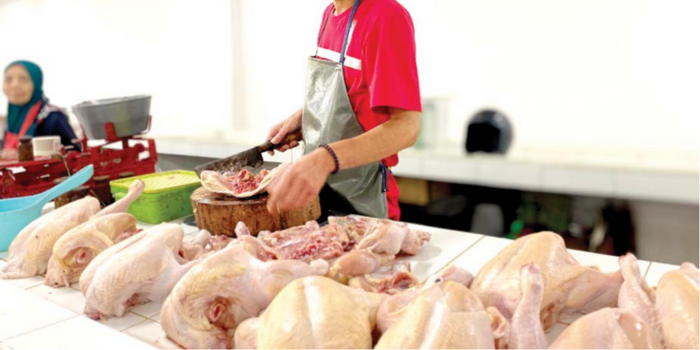HARGA TURUN: Salah seorang pedagang sedang memotong daging ayam ras di Pasar Induk Among Tani Batu kemarin (14/4).