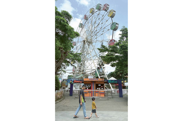 IKONIK: Ferris wheels atau bianglala di Alun-Alun Kota Wisata Batu tak beroperasi. Rencana pembangunan baru dilakukan tahun depan. (RORI DINANDA BESTARI/RADAR BATU)