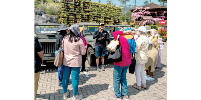 ANTUSIAS: Salah seorang tour guide memandu wisatawan yang berkunjung ke Kota Batu beberapa waktu lalu. (BGC KOTA BATU FOR RADAR BATU)